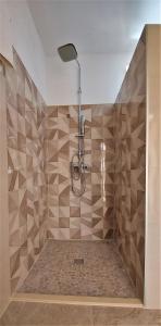 a bathroom with a shower with brown tiles at Apartments Kapetanovina in Mostar