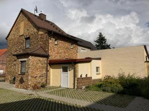 una casa de ladrillo con una puerta blanca al lado de un edificio en Gästehaus zur Bienerei, en Bad Schmiedeberg