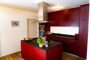 a kitchen with red cabinets and a black counter top at Valletta in Arosa