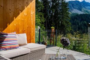 a wicker couch sitting on a patio with a fence at Valletta in Arosa