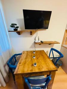 a wooden table with two chairs and a television on a wall at Studio Kris Villa Park in Borovets