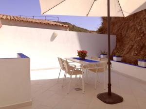 a table and chairs with an umbrella on a patio at La Porta Blu in Teulada
