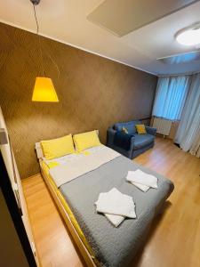 a bedroom with a large bed and a blue couch at Studio Kris Villa Park in Borovets