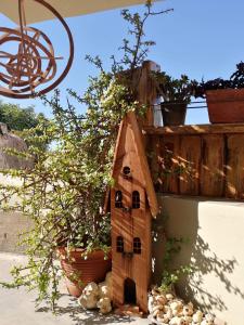 a bird house on a wall with potted plants at Domatia me Thea in Elafonisos