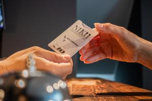 dos manos sosteniendo un pedazo de papel con la palabra música en Nikii City Hotel en Leverkusen