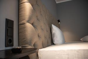 a bedroom with a bed with a padded headboard at Nikii City Hotel in Leverkusen