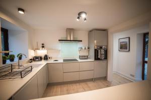 a large kitchen with white cabinets and a sink at Timber Hill - Parkfields in Haverfordwest