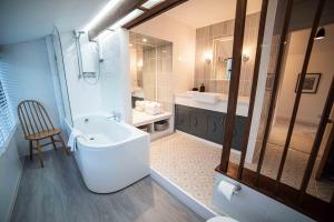 a bathroom with a tub and a toilet and a sink at Timber Hill - Parkfields in Haverfordwest