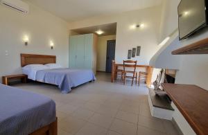 a hotel room with two beds and a table and chairs at Domatia me Thea in Elafonisos
