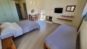 a hotel room with two beds and a television at Domatia me Thea in Elafonisos