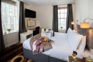 a hotel room with a large bed with bags on it at Kildare House Hotel in Kildare