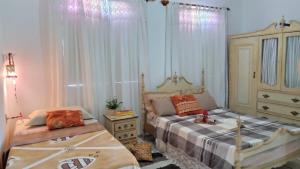 1 dormitorio con 2 camas y vestidor en Vivenda Porto, conforto e estacionamento free no centro da cidade, en Porto Seguro