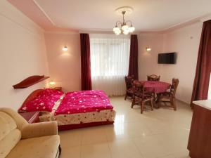 a bedroom with a bed and a dining room with a table at Solar Apartmanok in Hajdúszoboszló