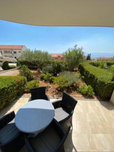 a table and chairs on a patio with a view at Apartments Lovely Croatia in Bol