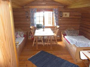 ein Esszimmer mit einem Tisch und Bänken in einer Blockhütte in der Unterkunft Åsgardane Gjestegard in Gol
