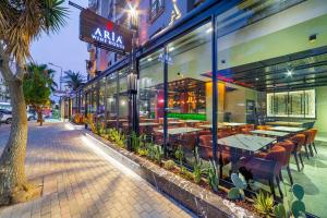 a restaurant with tables and chairs outside of a building at Aria Riva Apart Hotel in Alanya