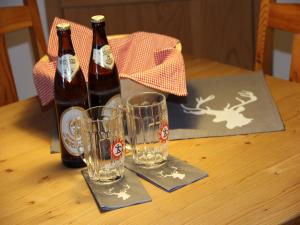dos botellas de cerveza y dos vasos en una mesa en Casa Claudia - die schöne 4-Sterne-Fewo - im Sommer Bergbahntickets inclusive, en Oberstdorf