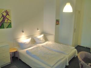 1 dormitorio con 1 cama con sábanas y almohadas blancas en Last Minute Rügen, en Lohme