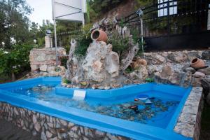 a fish pond with a fountain in a garden at Akrathos Houses in Polychrono