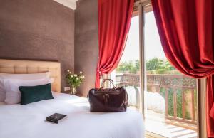 a bag on a bed in a room with a balcony at dar al walidine in Marrakesh