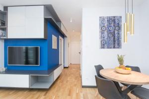 a dining room with a table and a tv at Apartament Rodzinny Portova in Gdynia