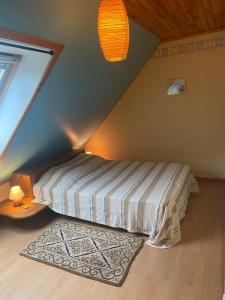 1 dormitorio con cama y alfombra en el ático en hébergement du chêne, en Fréland
