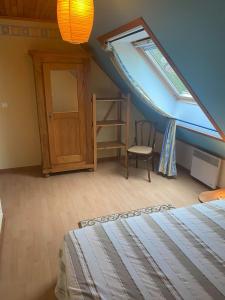 1 dormitorio con cama, ventana y escalera en hébergement du chêne, en Fréland