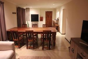 a dining room with a wooden table and chairs at du Repos (Lovely & Relaxing 2-Bedroom Unit with Patio) in Springbok