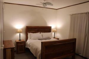 du Repos (Lovely & Relaxing 2-Bedroom Unit with Patio) في جلوسوب: غرفة نوم بسرير كبير مع وجود مصباحين على الطاولات