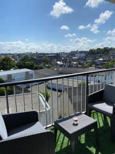 - un balcon avec deux chaises et une table avec vue dans l'établissement Appartement quartier calme. Proche Port et plages., à Saint-Brieuc