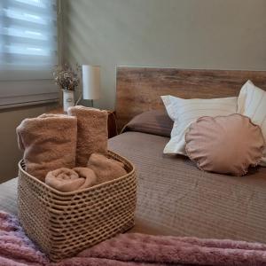 Una cama con una cesta de toallas. en Cabral - Departamento en la mejor zona de Mendoza en Mendoza