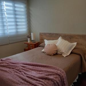 una camera da letto con un grande letto con un cuscino sopra di Cabral - Departamento en la mejor zona de Mendoza a Mendoza