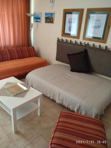 コスタ・デル・シレンチオにあるMaravillaのベッド2台、ソファ、テーブルが備わる客室です。