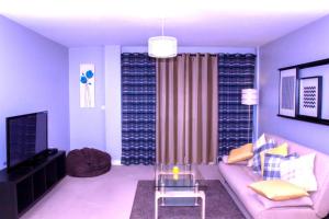 a living room with a couch and a tv at Allen Luxury Apartment in Coventry