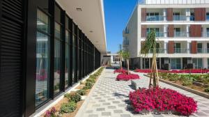 Un edificio con un patio con flores y plantas. en Long Beach Holiday Resort, en Iskele