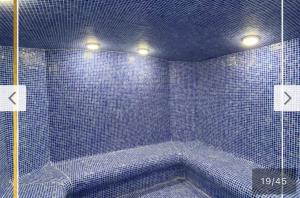 Baño de azulejos azules con bañera con 2 luces en Long Beach Holiday Resort, en Iskele 16 fotos más