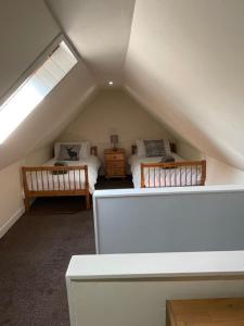 a attic room with two beds and a window at 1-2 Dialknowe Holiday Cottage - Wanlockhead in Wanlockhead +2 photos