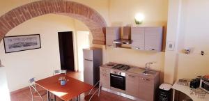 La cuisine est équipée d'une table, d'une cuisinière et d'un réfrigérateur. dans l'établissement Da Simone podere santi Lucia e Pietro, à Sienne
