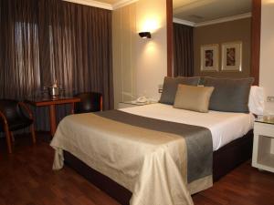 um quarto com uma cama grande num quarto de hotel em Motel Aeropuerto em Vigo