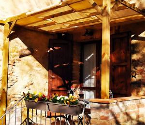 une terrasse couverte d'une maison avec une table et des fleurs dans l'établissement Da Simone podere santi Lucia e Pietro, à Sienne