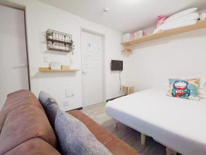 a living room with a couch and a bed at YUYU-Yo-3 --Self Check-in -- Room Number & Password is in the following email in Tokyo