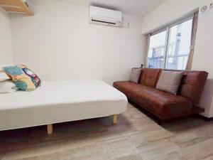 a living room with a couch and a bed at YUYU-Yo-3 --Self Check-in -- Room Number & Password is in the following email in Tokyo