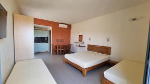 a bedroom with a bed and a kitchen with a table at Domatia me Thea in Elafonisos