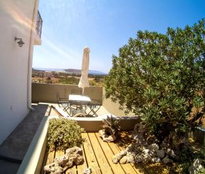 a patio with a table and a chair and a tree at Domatia me Thea in Elafonisos