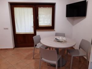 ein Esszimmer mit einem Tisch, Stühlen und einem TV in der Unterkunft Villa Lucilla in Altavilla Silentina