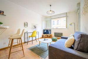 ein Wohnzimmer mit einem blauen Sofa und einem Tisch in der Unterkunft LE MONTMORENCY - Free Parking - Airbus - Netflix in Toulouse
