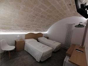 Pokój z 2 łóżkami, stołem i krzesłem w obiekcie President House Matera w mieście Matera