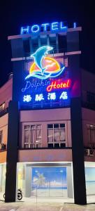 a building with a neon sign on it at Dolphin Hotel in Klang