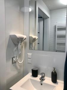 a bathroom with a sink and a mirror at Apartamenty Chata u Rybaka in Jantar