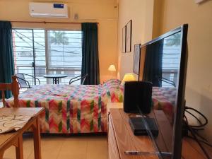 - une chambre avec un lit, une télévision et une table dans l'établissement B3 Apartments, à Formosa